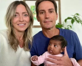 Two adults holding a baby. Two adults holding a baby.