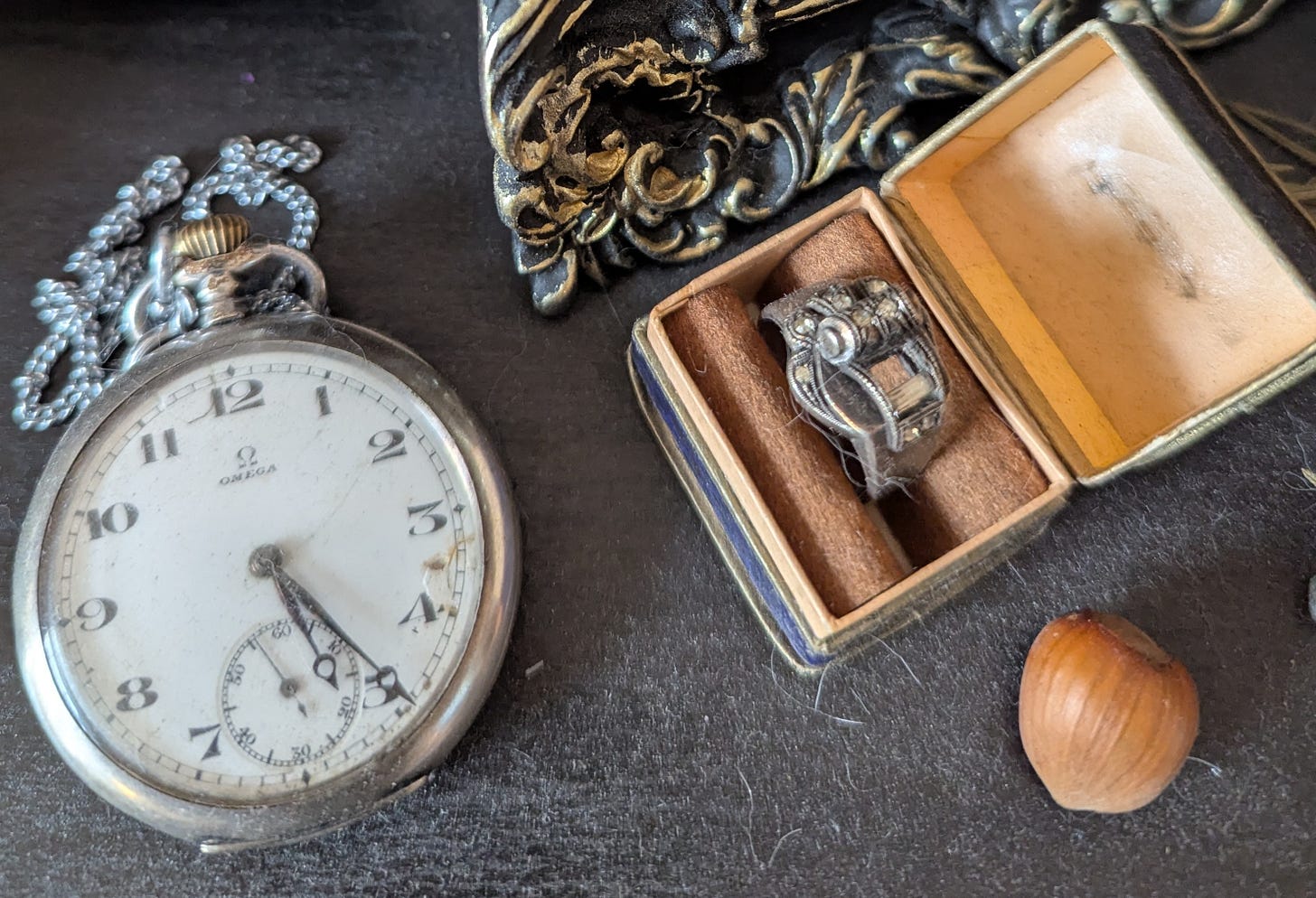 picture of an antique pocket watch and a ring, likely from the 1930s or 1940s