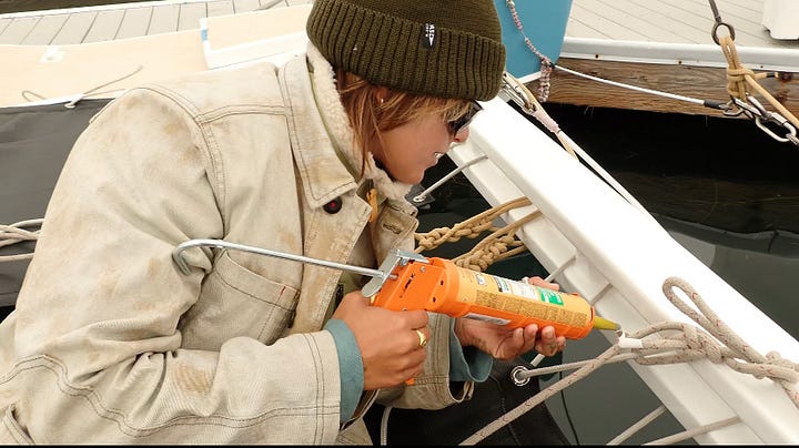 Working on the lashing for the back of the canoe on the water, using a trigger gun to apply quick dry marine crack repair to exposed wood on the boat, chris eating in n out with a big smile, our teak wood center board in place on ʻAʻĀ