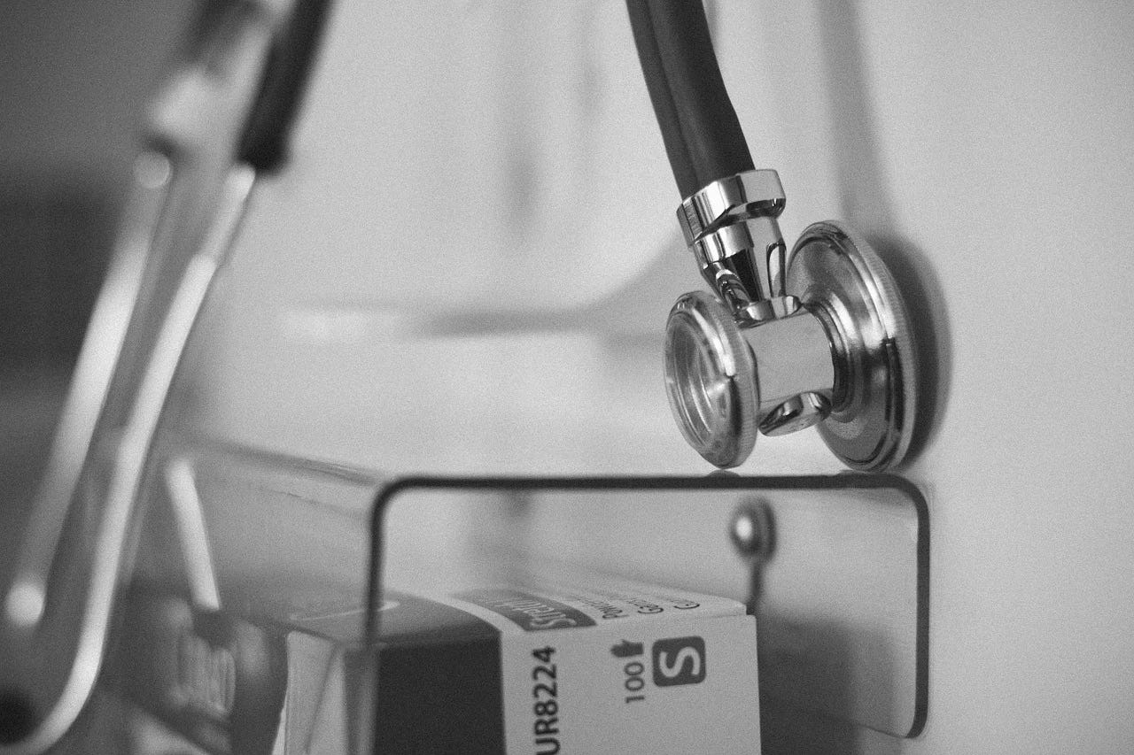 photo of stethoscope and medical supplies in greyscale