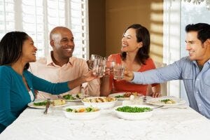 Friends at a table toasting with glasses of water