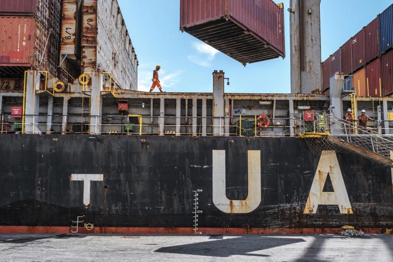 A worker walks on a container ship at the Port of Victoria, on the island of Mahe, Seychelles.