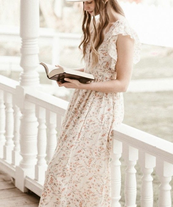 woman in white dress standing on white wooden bridge during daytime