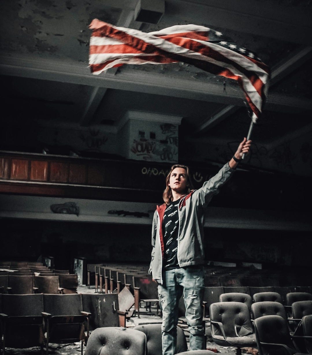 man rising US flag inside theater man rising US flag inside theater