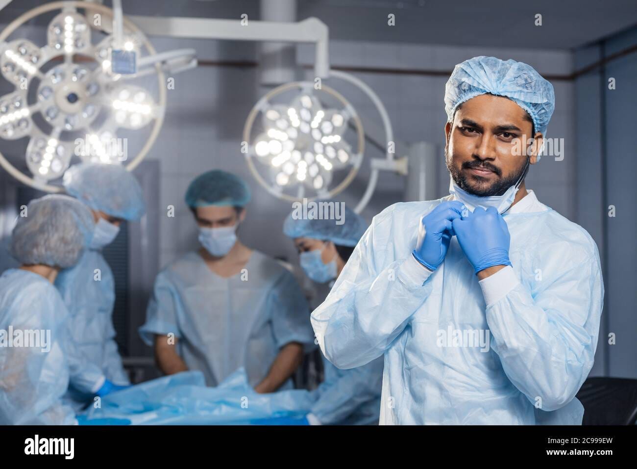 Confident Indian surgeon looking at camera in surgical room hospital,  medical doctor wear green surgery scrub suit Stock Photo - Alamy