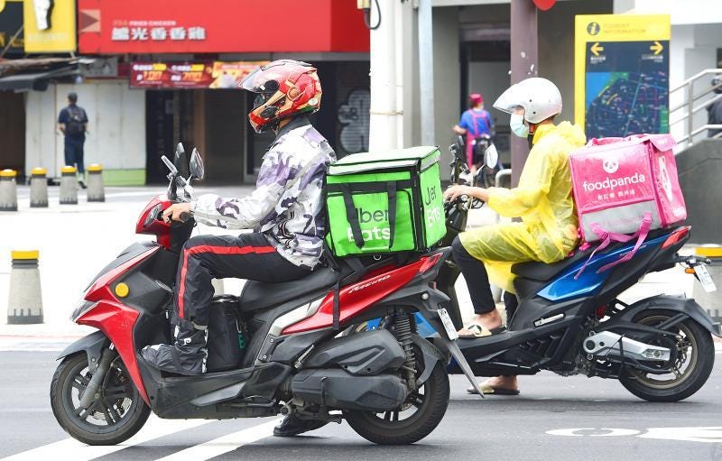 Uber Eats與Foodpanda外送員在台北路口等待紅燈|來源:Liu Hsin-de / Taipei Times Uber Eats與Foodpanda外送員在台北路口等待紅燈|來源:Liu Hsin-de / Taipei Times