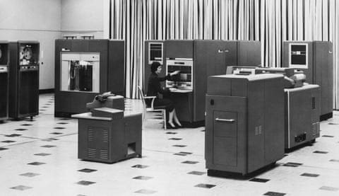A woman operates the control panel of an IBM 650 computer among large mainframe units A woman operates the control panel of an IBM 650 computer among large mainframe units