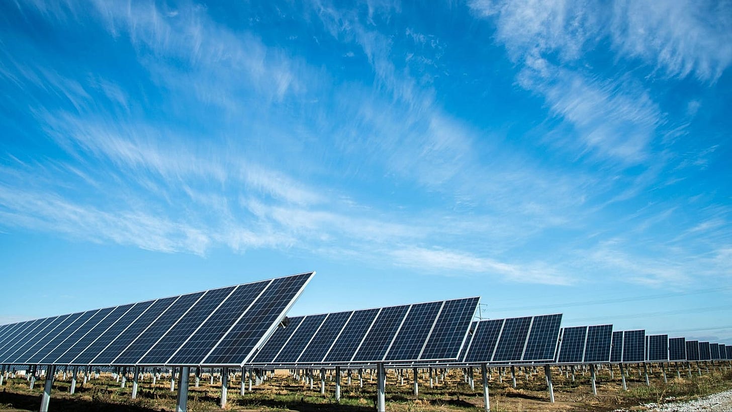 Ground-mounted solar panels beneath a blue sky. Ground-mounted solar panels beneath a blue sky.