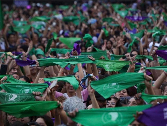 A large group of people holding green and purple flags
AI-generated content may be incorrect. A large group of people holding green and purple flags
AI-generated content may be incorrect.
