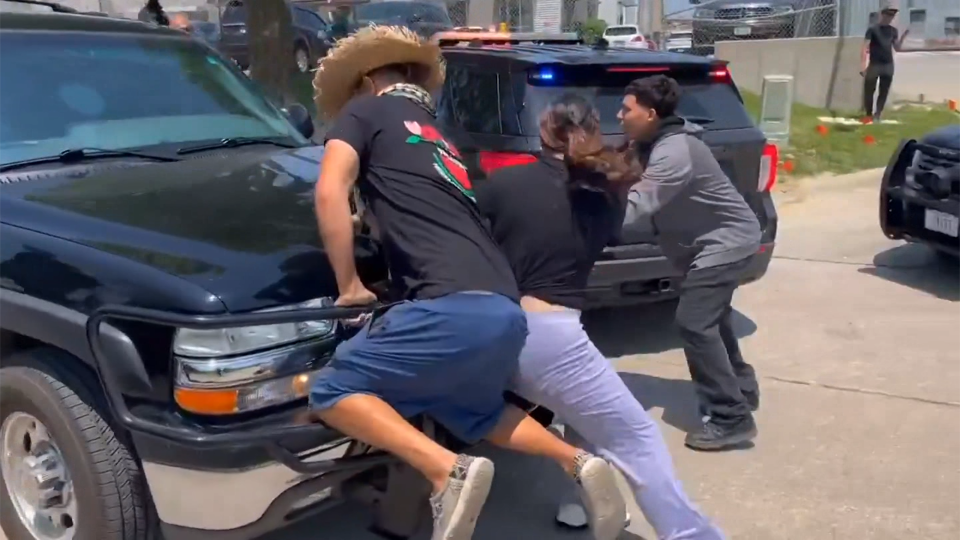 Meatpacking employees block ICE cars with their bodies following raid