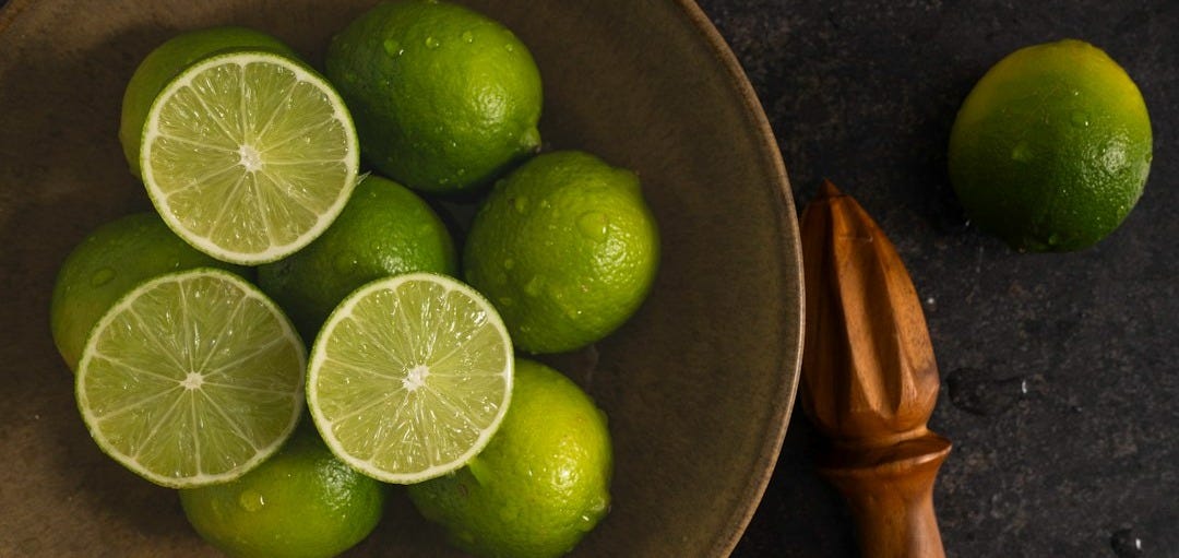 a bowl of limes and a knife on a table a bowl of limes and a knife on a table