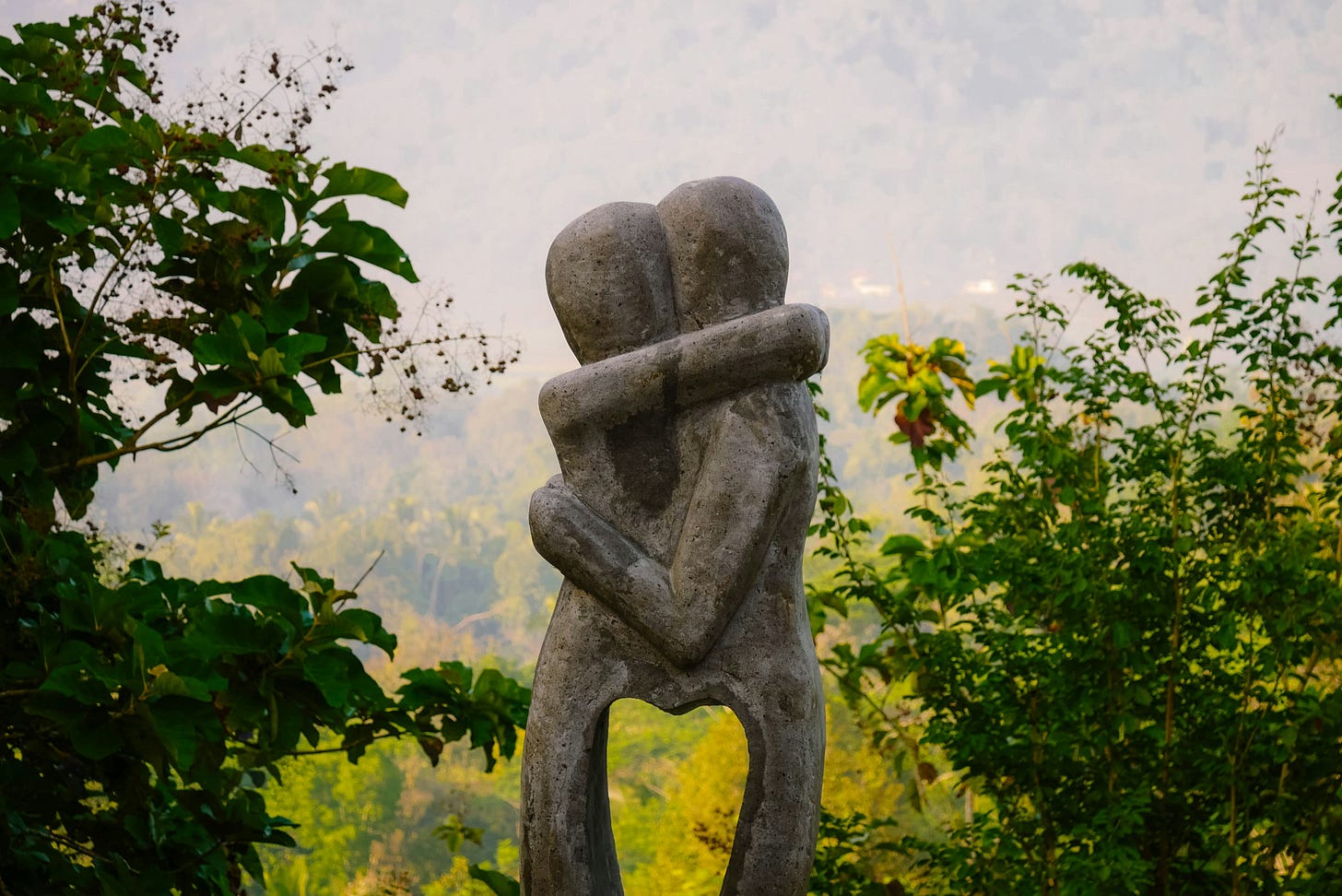 Two stone statues embracing and forming a heart with their bodies