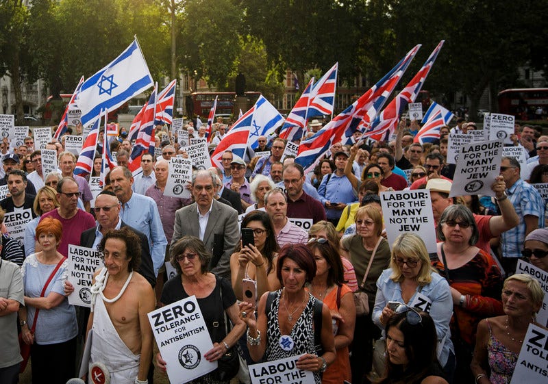 A crown of demonstrators raises British and Israeli flags A crown of demonstrators raises British and Israeli flags