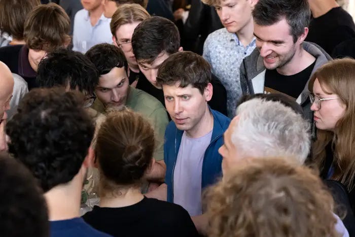Sam Altman dev do ChatGPR rodeado por pessoas.