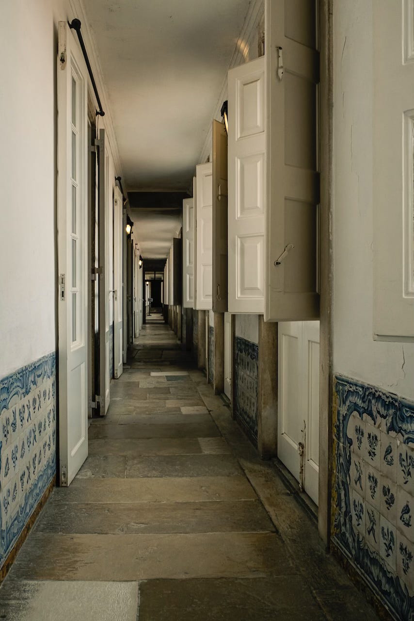A corridor lined with windows, inside the palace, University of Coimbra.