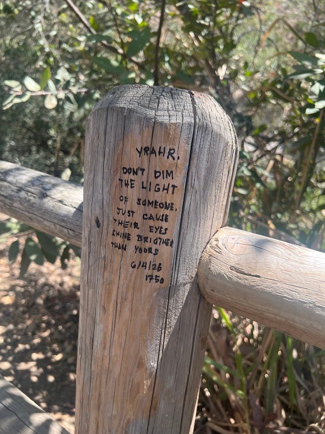 Photos of a desert hike featuring pictures of brown landscape, a waterfall, the author, a teepee, and a fence post with a quote on it.