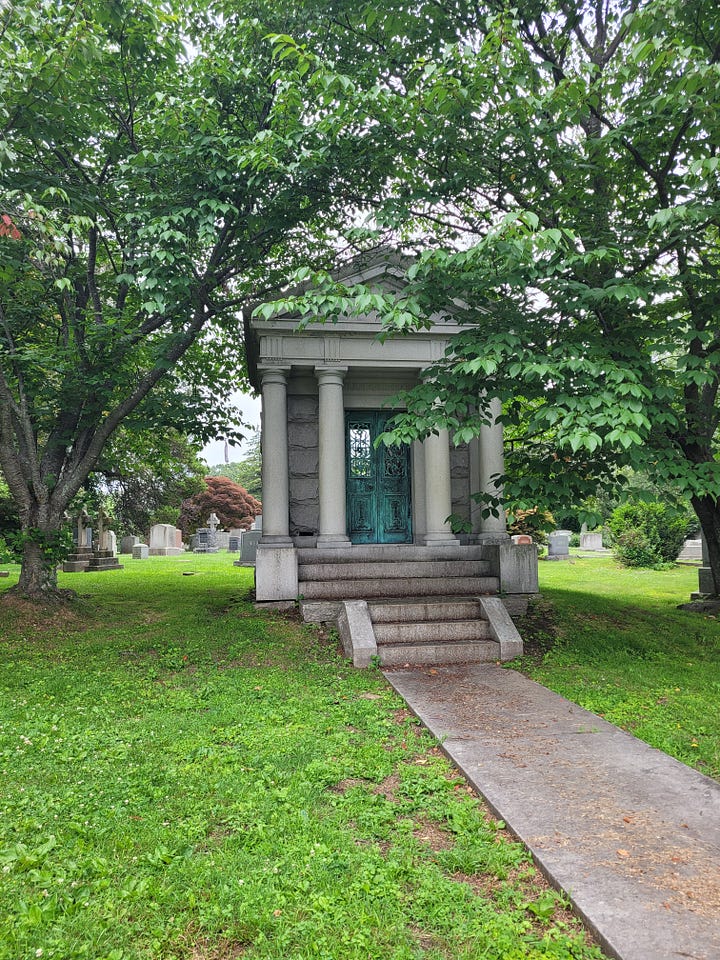 Left: headstone reading 'Bell' in copper that has turned teal; R: Single-family mauseleum with stone columns
