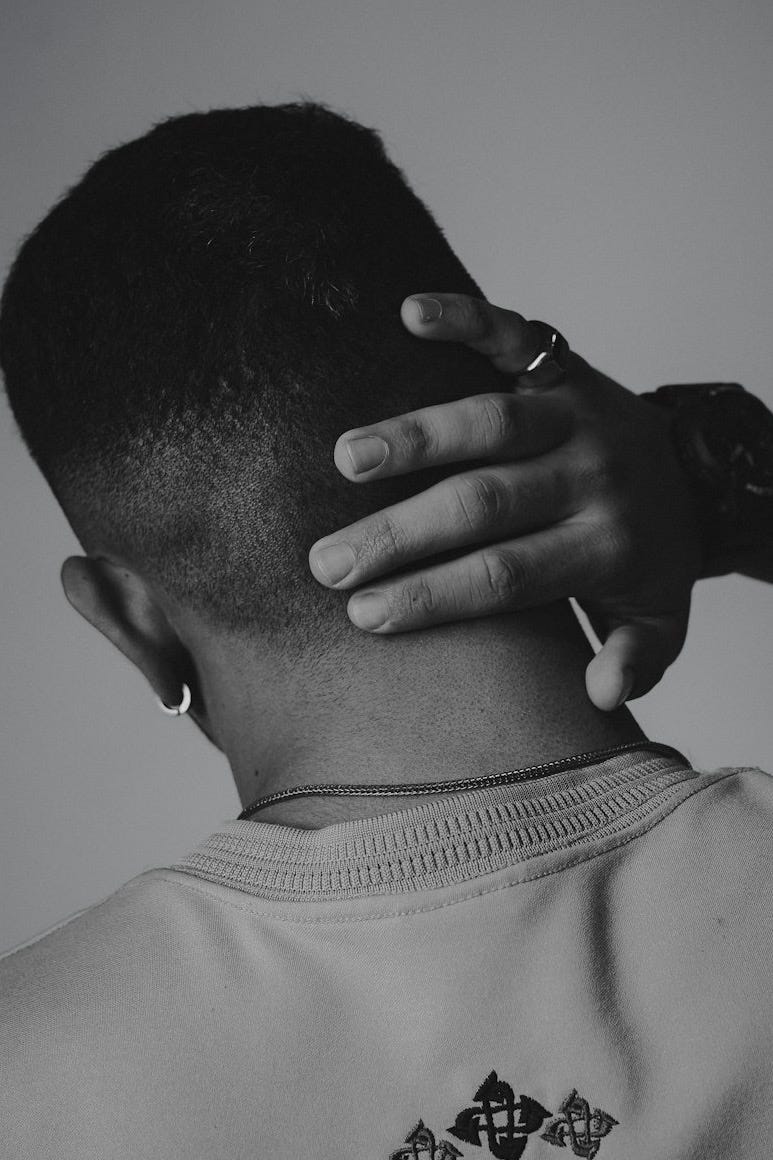 a black and white photo of a man with his hands on his head