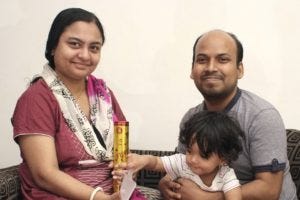 Api and Chandan Sahan seated on a sofa with their young son Api and Chandan Sahan seated on a sofa with their young son