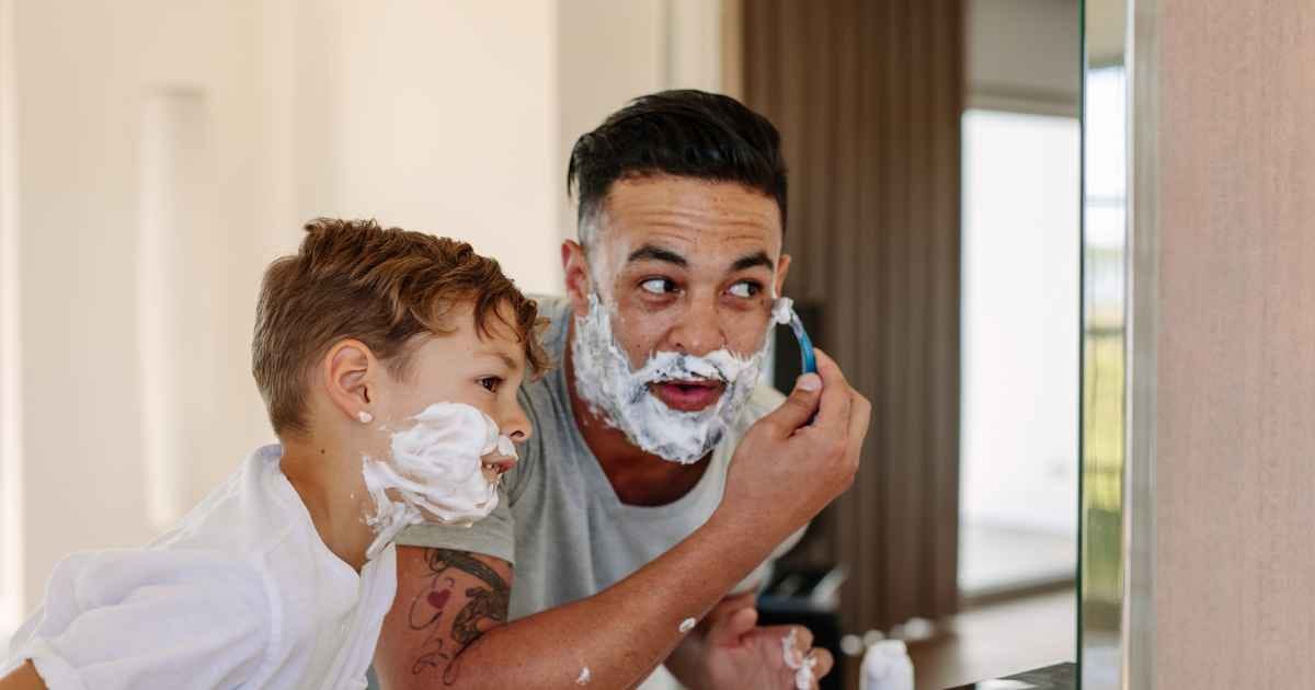 Father and son shaving together in the bathroom