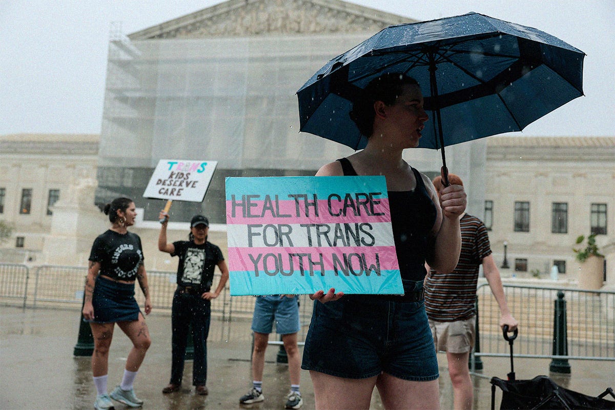 A protester holds a sign in support of gender-affirming care for transgender youth outside of the U.S. Supreme Court Building on June 18, 2025