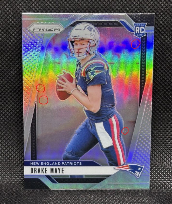 Example of front surface dimples for PSA grading on 2024 Drake Maye Prizm Silver Rookie Card #329. Example of front surface dimples for PSA grading on 2024 Drake Maye Prizm Silver Rookie Card #329.
