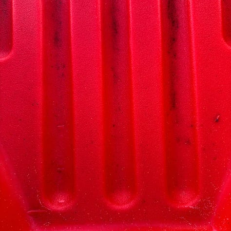 Photographs show a range of red subjects - a notebook cover top left, a close up of a plastic red toy, a faded red post office sign, a red letter box, a red and white rope on a dog toy and a red sign offering home made coffe