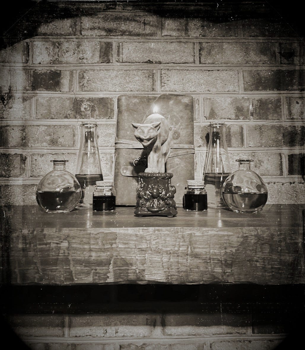 A sepia-toned photo made to look like a Victorian era daguerreotype. The photo shows a lit candle in the shape of a cat sitting among a display of potion bottles and a leather journal.