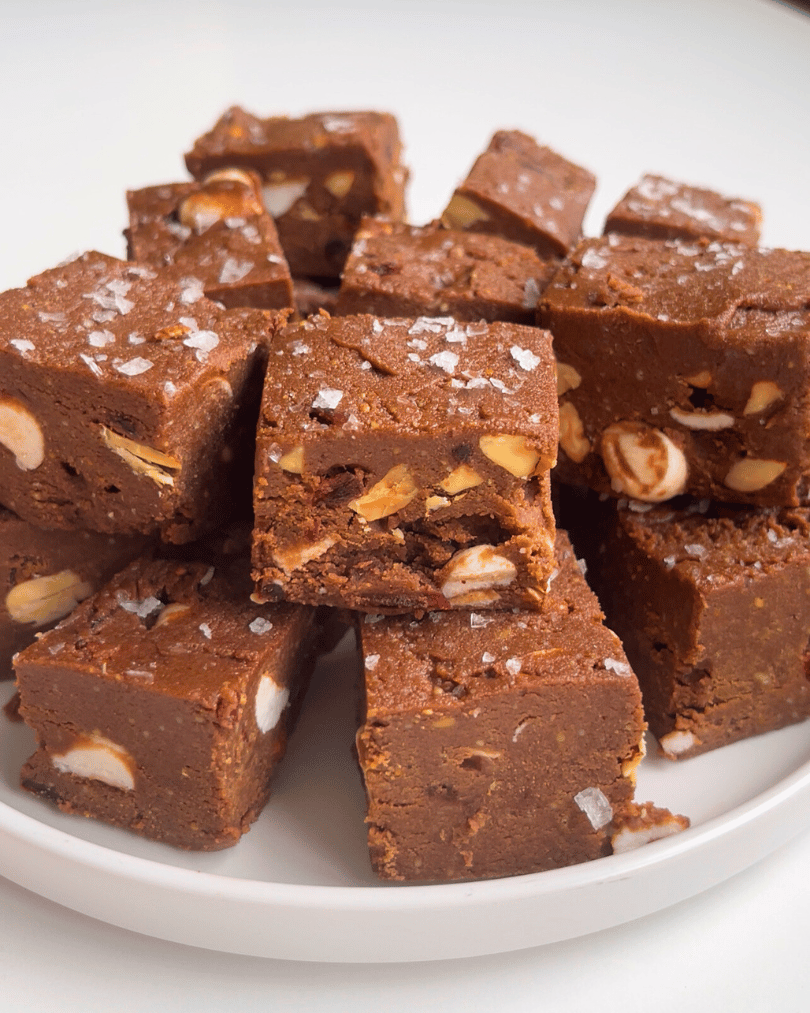 freezer protein fudge sliced into squares on a white plate with coarse sea salt on top