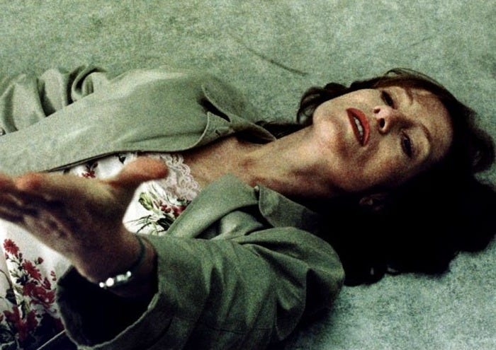This may contain: a woman laying on the ground with her hand out