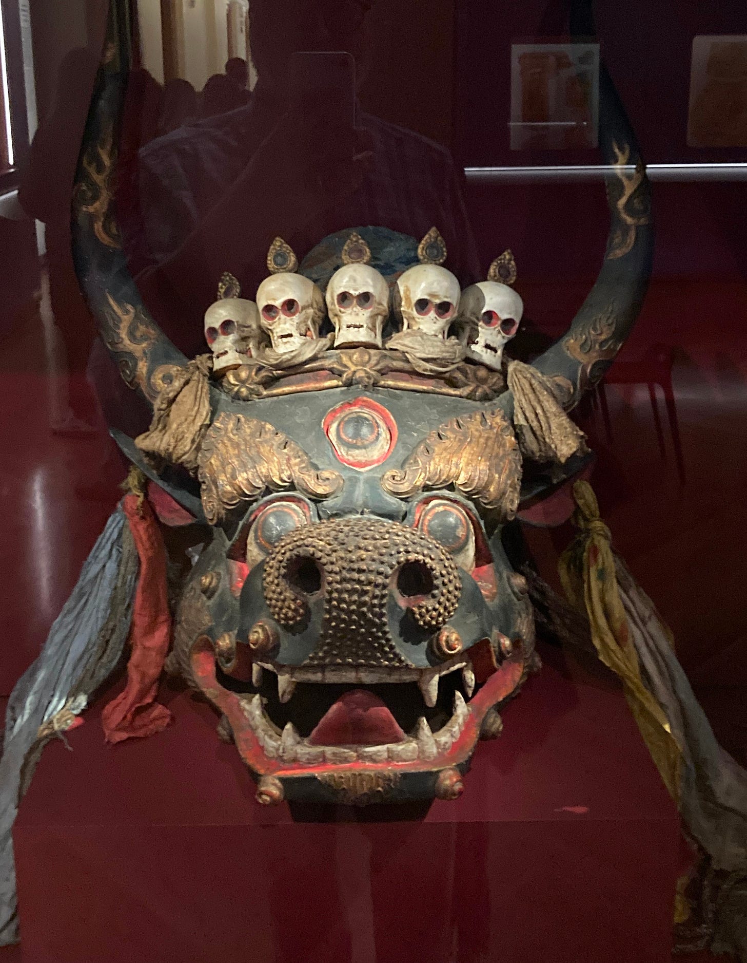 Picture of a Yama Mask. Five small skulls sit on top of a horned bull's head. Picture of a Yama Mask. Five small skulls sit on top of a horned bull's head.