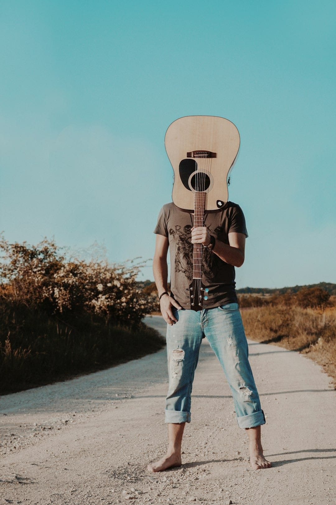 man holding brown acoustic guitar man holding brown acoustic guitar