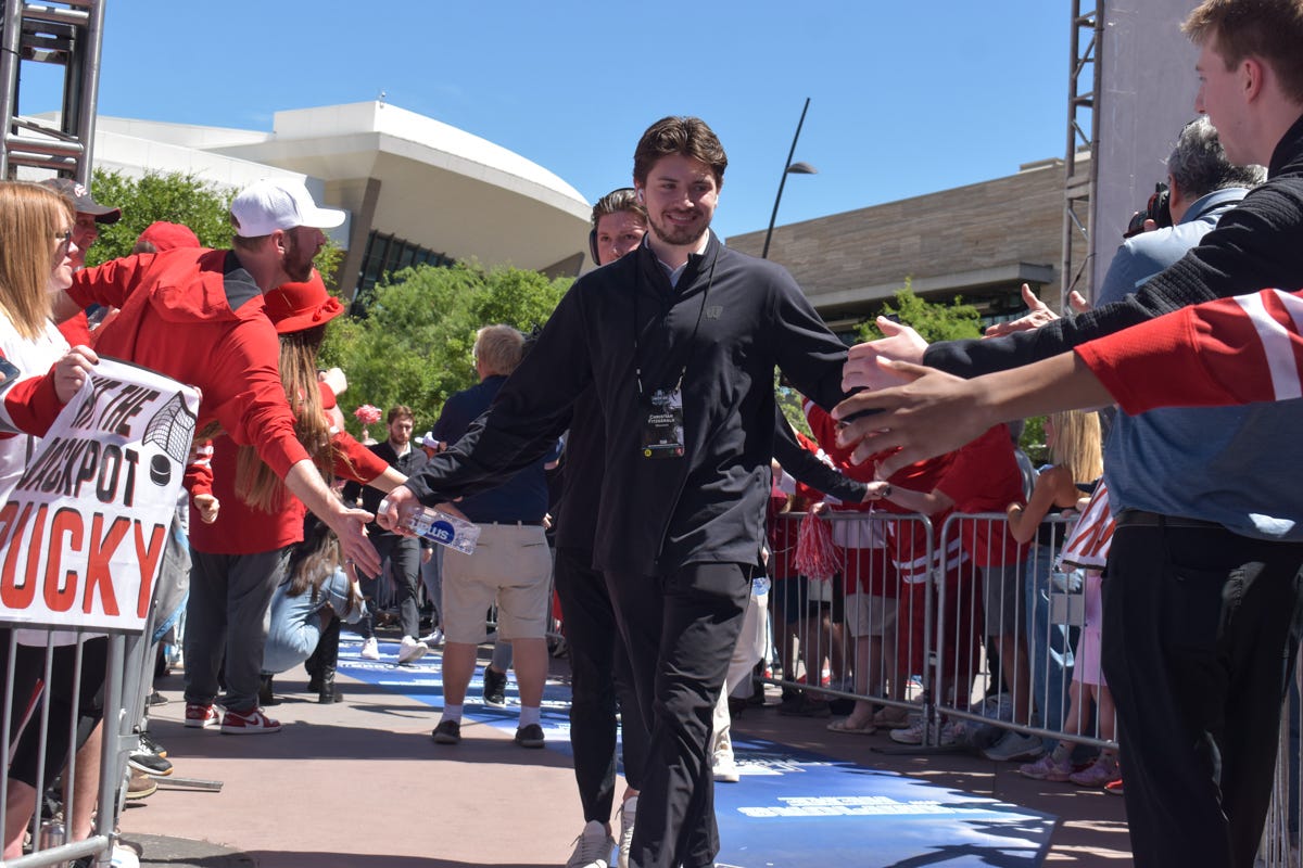 Christian Fitzgerald in all black with fans on either side of him