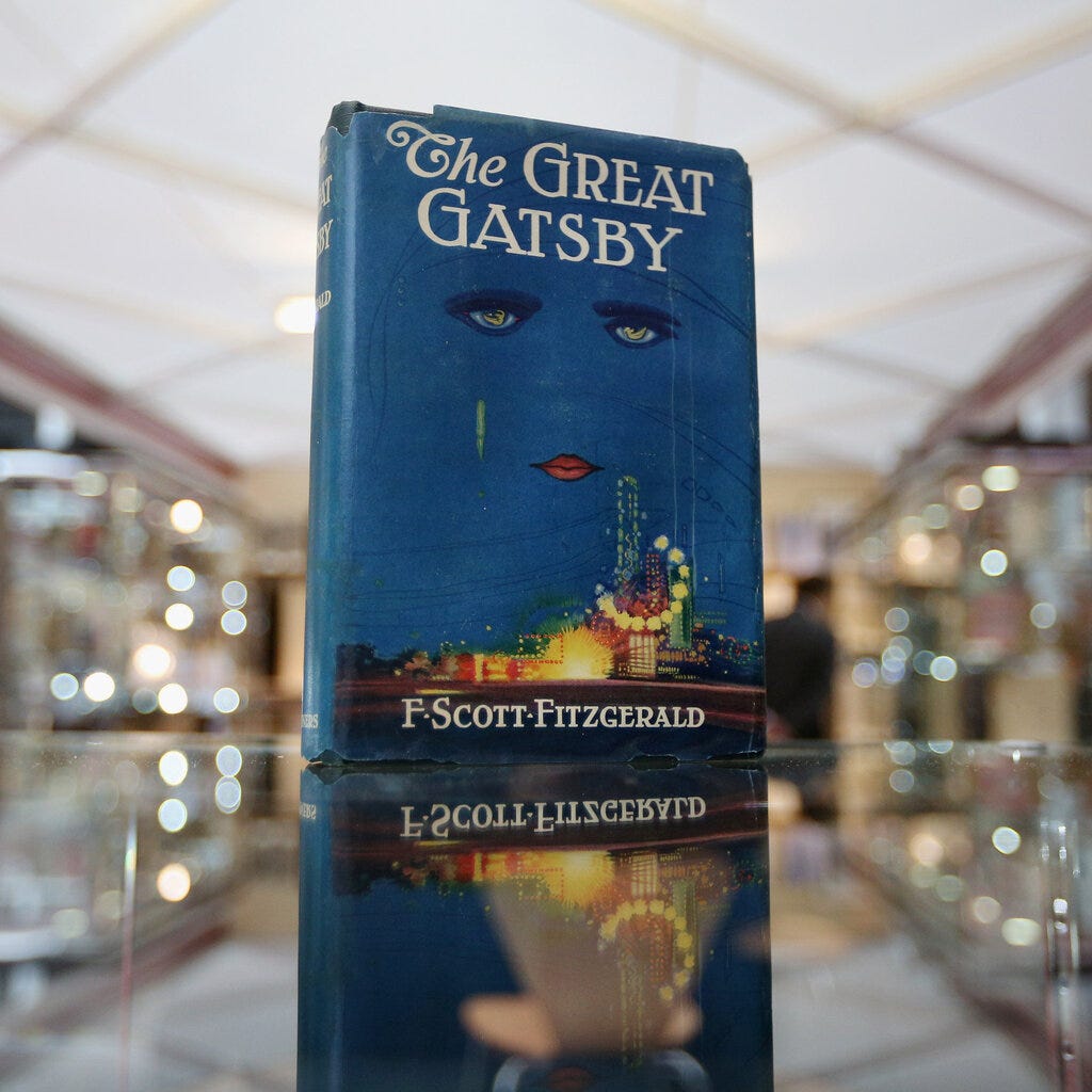The book “The Great Gatsby,” with its iconic cover of a woman’s face floating in the sky above the city lights. 