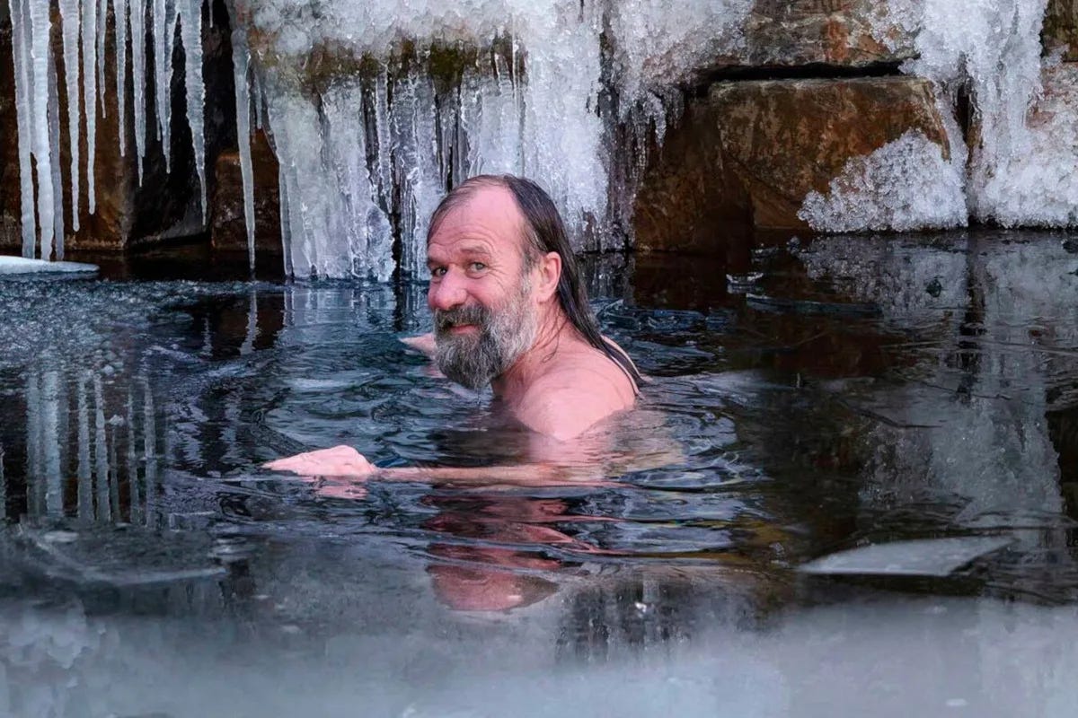 Photo of Wim Hof in a frozen lake, icicles are covering a rock behind him. He is looking at the camera. Photo of Wim Hof in a frozen lake, icicles are covering a rock behind him. He is looking at the camera.