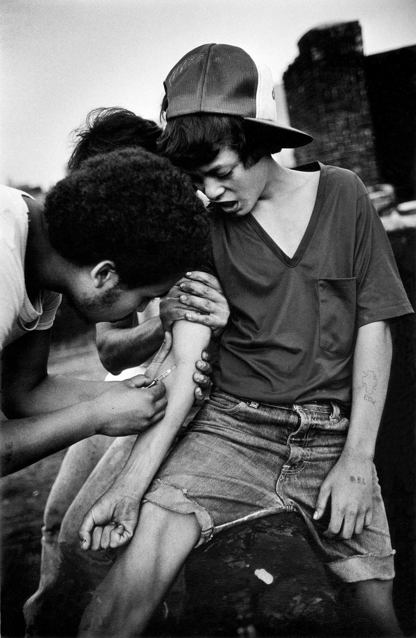 A friend helps a 15 year old boy shoot up heroin on the roof of an abandoned building, The Bronx New York - 1983 A friend helps a 15 year old boy shoot up heroin on the roof of an abandoned building, The Bronx New York - 1983