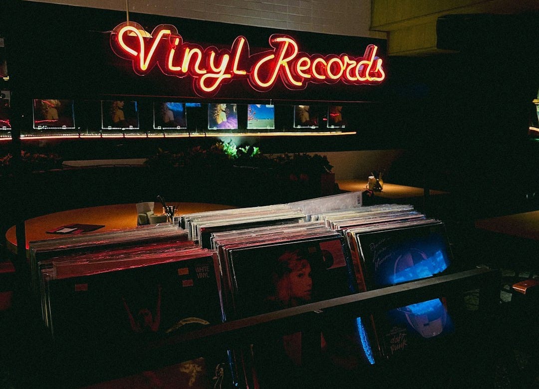 a large neon sign that reads vinyl records