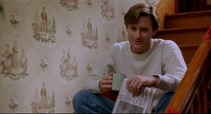 Still from WHILE YOU WERE SLEEPING that shows Bill Pullman sitting on the steps with his newspaper and coffee, wearing a comfy-looking white sweater Still from WHILE YOU WERE SLEEPING that shows Bill Pullman sitting on the steps with his newspaper and coffee, wearing a comfy-looking white sweater