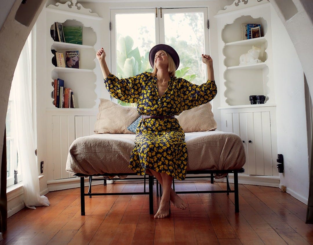 woman in brown and black floral dress sitting on brown wooden chair