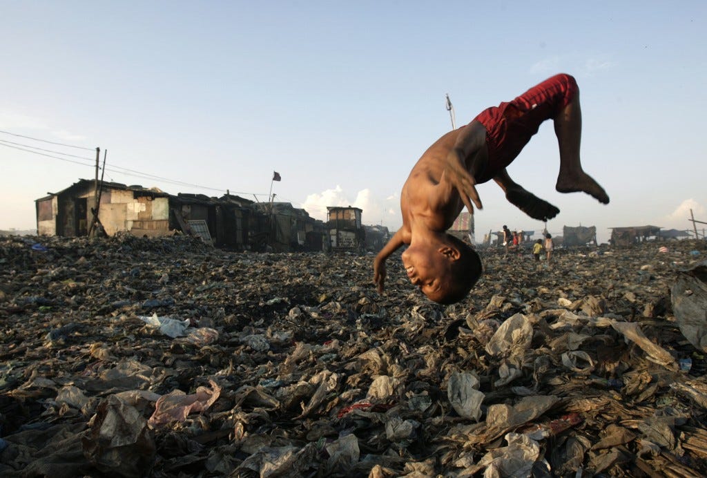 A boy plays at a garbage dump where hundreds of people stay and make a living out of recycling waste and making charcoal in Tondo, Manila in 2007. Photo by Darren Whiteside/Reuters