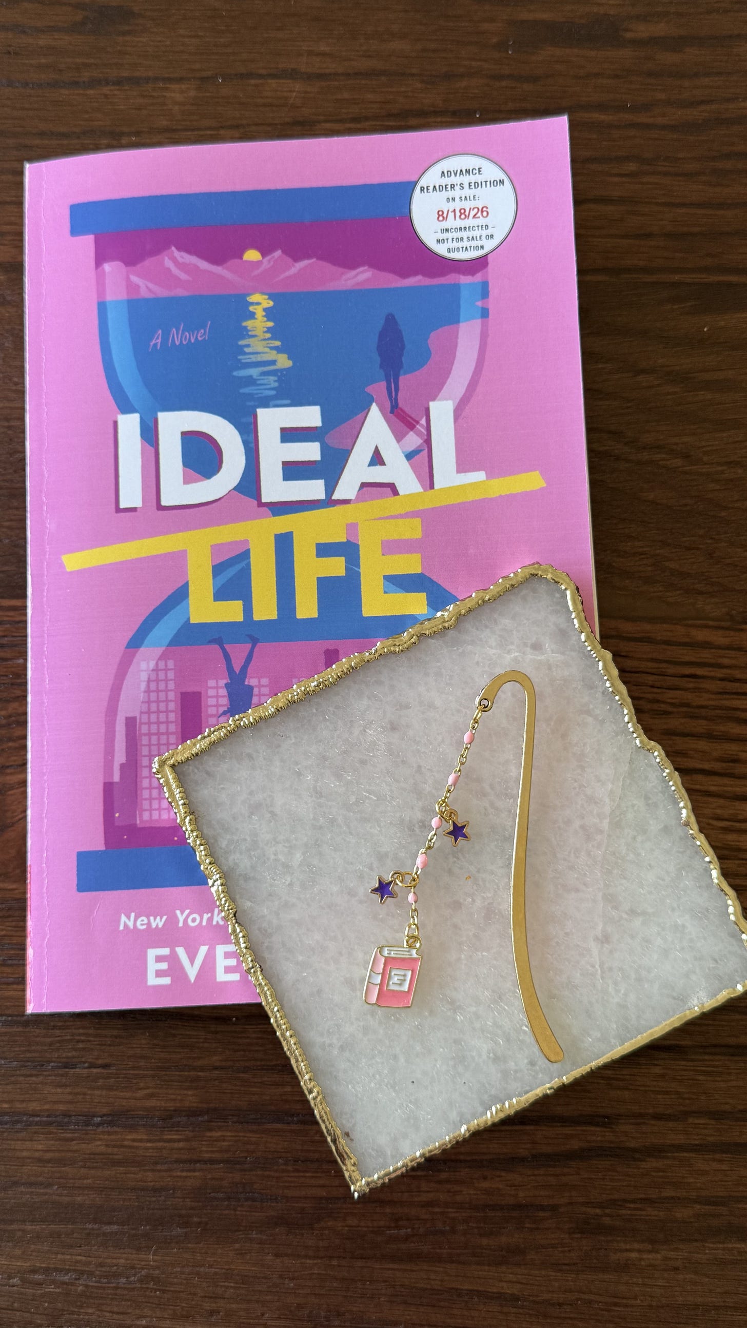 IDEAL LIFE ARC in bright pink with hourglass graphic, together with a gold metal bookmark with pink beads, purple star charms and pink book charm