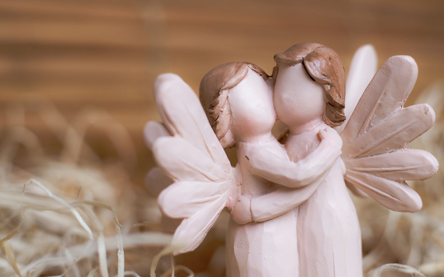 Two carved wooden angels hugging each other Two carved wooden angels hugging each other