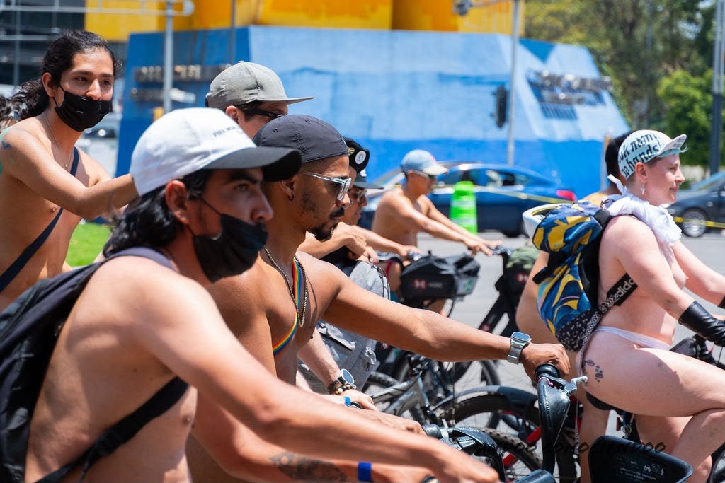Nude and partially nude cyclists ride together through a Mexico City street during the 2026 World Naked Bike Ride. Several riders wear backpacks, caps, masks, or body paint.A small group of nude and partially nude cyclists rides in profile along a Mexico City street during the 2026 World Naked Bike Ride. Several riders wear caps, masks, or backpacks. Nude and partially nude cyclists ride together through a Mexico City street during the 2026 World Naked Bike Ride. Several riders wear backpacks, caps, masks, or body paint.A small group of nude and partially nude cyclists rides in profile along a Mexico City street during the 2026 World Naked Bike Ride. Several riders wear caps, masks, or backpacks.