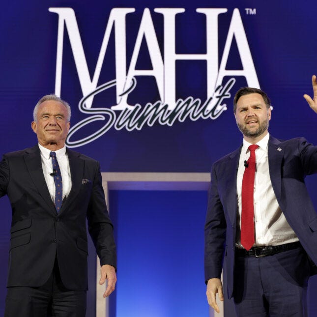 RFK Jr. and JD Vance standing on stage in front of a large illuminated 'MAHA Summit' backdrop; one waves to the crowd."
