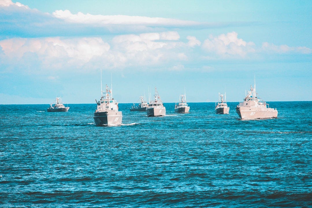seven navy ship sailing on ocean during daytime seven navy ship sailing on ocean during daytime