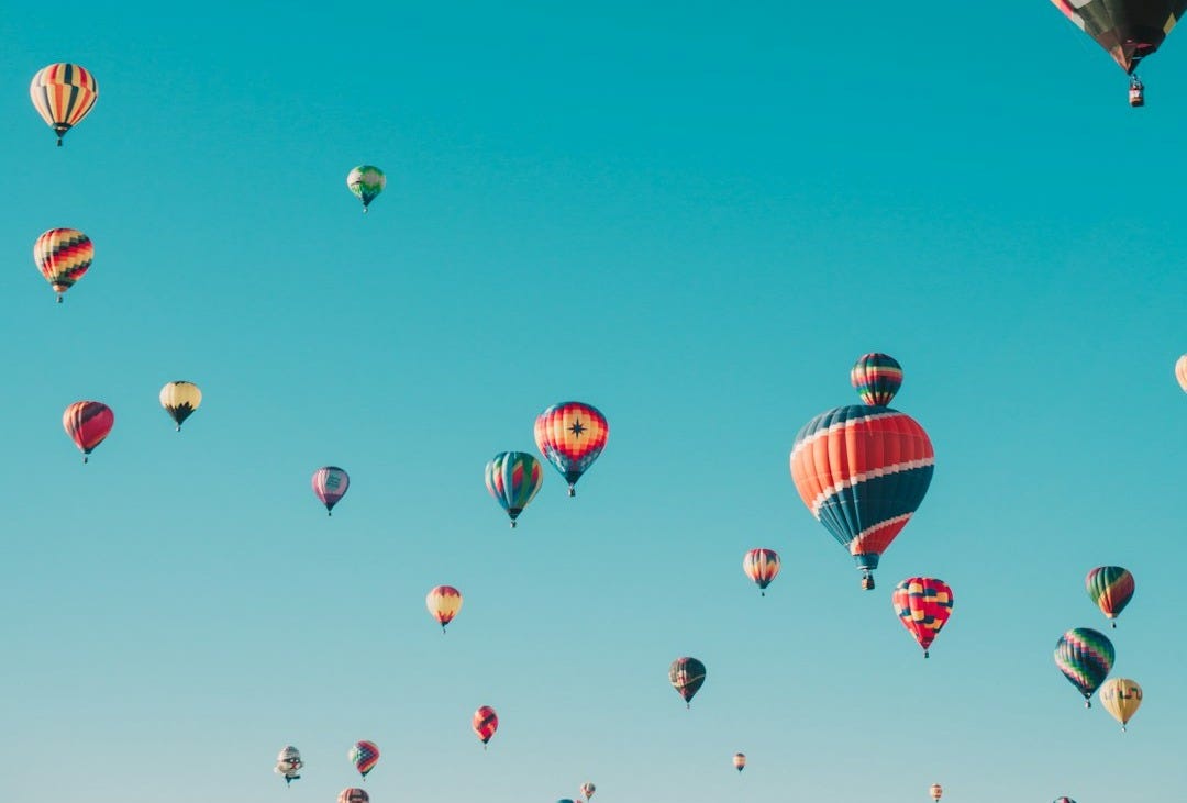 assorted hot air balloons flying at high altitude during daytime assorted hot air balloons flying at high altitude during daytime