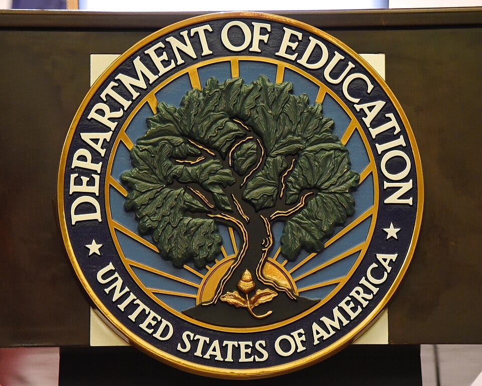 a circular seal with a tree in the middle and text around the outside reading Department of Education, United States of America a circular seal with a tree in the middle and text around the outside reading Department of Education, United States of America