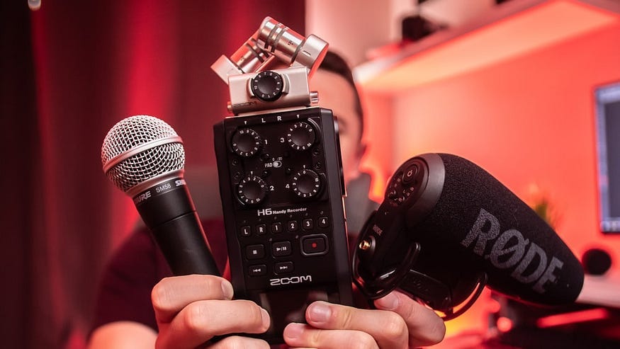 A person holds up sound equipment.