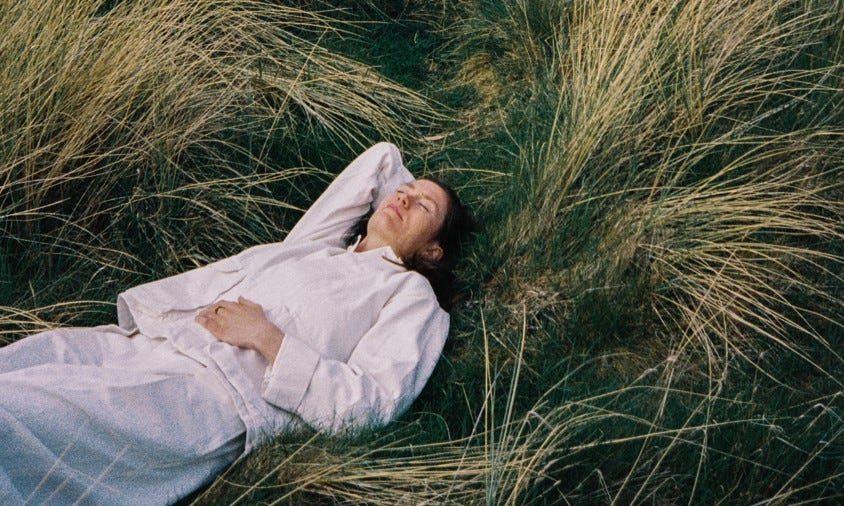 A photo of Rachel Sermanni, dressed in all white, on her back in long grass. Her relaxed expression suggests she isn't concerned by grass stains. A photo of Rachel Sermanni, dressed in all white, on her back in long grass. Her relaxed expression suggests she isn't concerned by grass stains.