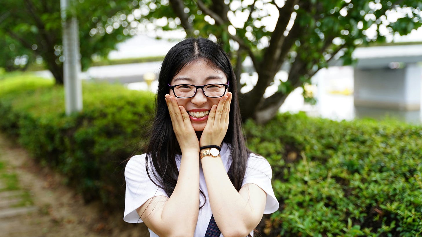Very excited woman with hands on her cheeks, standing outdoors. Photo by Zhang Yazhou via Unsplash.